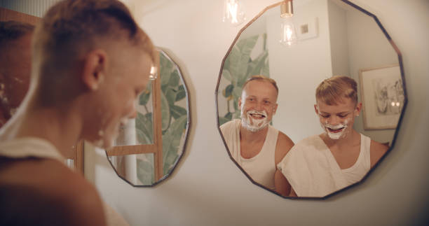 istock Father and son having fun shaving. Quality time with kid. Mirror reflection 1347445686