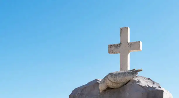 Photo of Religious cross against blue sky.