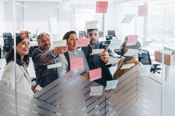 istock Business people talking in a work meeting sticking notes on a glass wall 1347449359