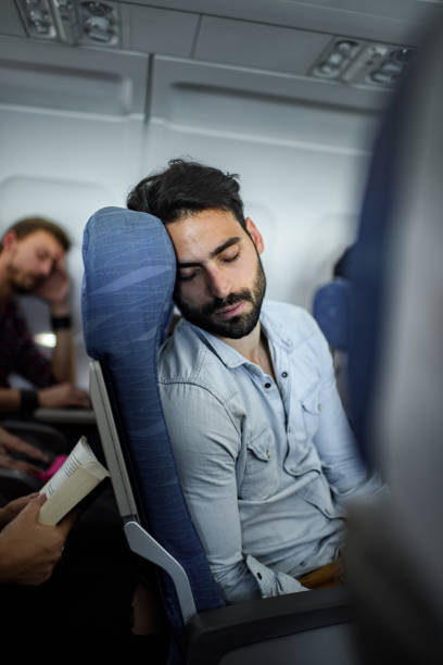 istock Young man taking a nap in the airplane. 1347449698