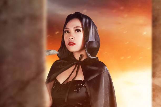 istock Asian witch woman with a cloak holding a knife standing 1347451255
