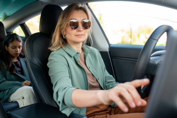 istock Young woman touching tablet display while driving car 1347452331