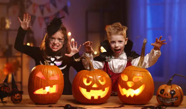 Photo of Children in Halloween costumes making trying to frighten during all hallows eve celebration