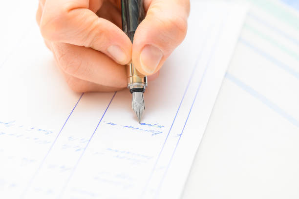 istock Hand holding and writing a note with a fountain pen. Close up view. 1347453969