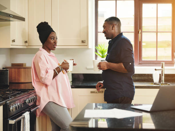 istock Shot of a young couple drinking coffee while having a chat with each other in the kitchen at home 1347455066