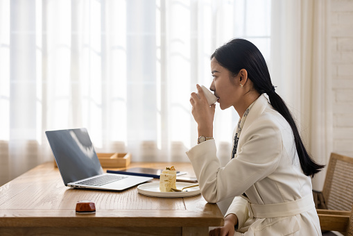 Young Asian businesswomen work with laptops in coffee shops