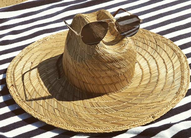 istock Beach hat and sunglasses on a beach towel. 1347455796