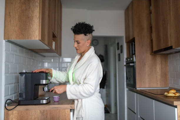 istock Mature woman making coffee at home 1347461539