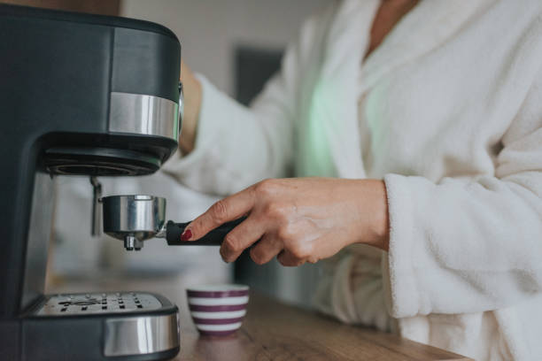 istock Mature woman making coffee at home 1347461558