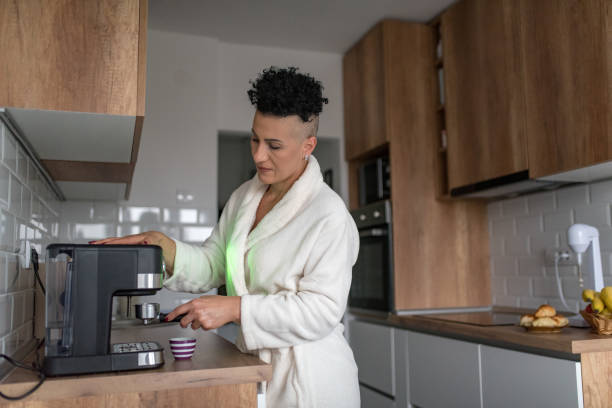 istock Mature woman making coffee at home 1347461559
