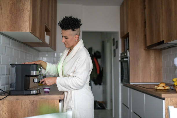 istock Mature woman making coffee at home 1347461565