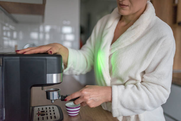 istock Mature woman making coffee at home 1347461567