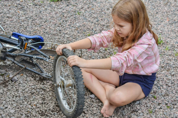 istock child girl has damaged a bicycle wheel and is making repairs photo without processing 1347462341