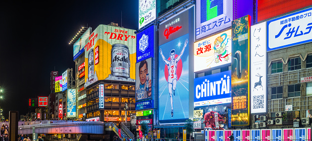Panoramic view along the Dotonbori Canal beneath the iconic neon billboards of this busy and popular shopping and restaurant district in the heart of Osaka, Japan’s vibrant second city.