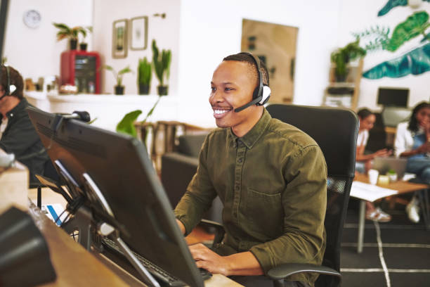 Shot of a handsome young businessman sitting in the office and wearing a headset while using a design monitor stock photo