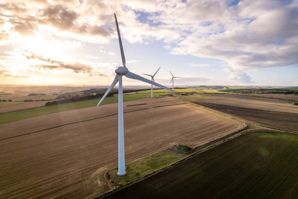 A Wind Turbine on a Green Renewable Energy Farm on a Sunny Day A wind turbine in Scotland on a sunny day providing sustainable, green and renewable energy. Farmers use their land to make additional income from wind power stations on their land greenhouse gas photos stock pictures, royalty-free photos & images