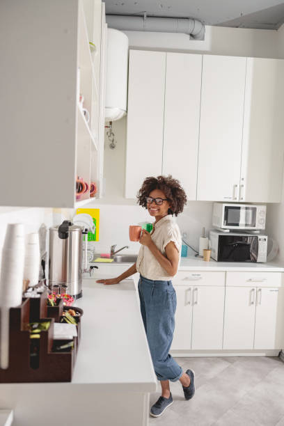 istock Pretty young employer having break in coworking kitchen 1347470144