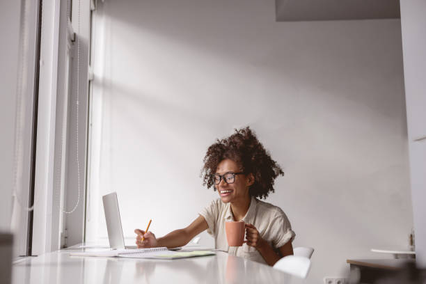 istock Joyful mixed-race woman in glasses writing down notes 1347470154