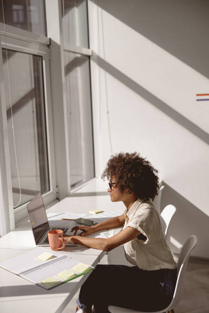 istock Smiling pretty woman looking at laptop screen during sunny day 1347470180