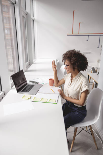 Woman communicating in sign language online at a laptop