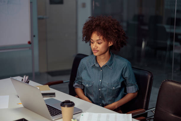 istock Smiling young businesswoman using laptop at her workplace 1347470323
