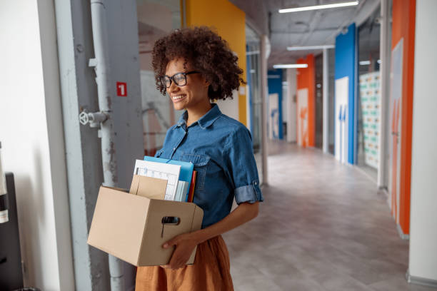 istock Happy female employer walking around the office with documents 1347470352