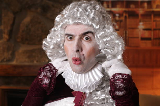 istock Pompous aristocratic man in vintage costume looking through magnifying glass 1347471934
