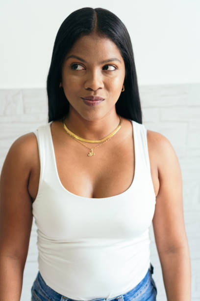 istock woman standing smiling and looking to the side. 1347473537