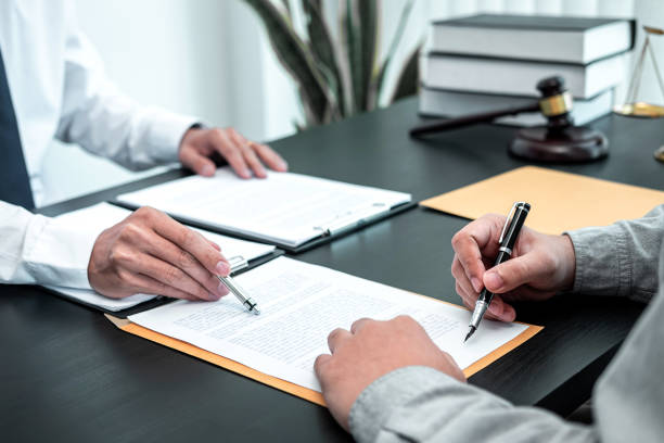 männlicher anwalt diskutiert verhandlungsrechtsfall mit mandantentreffen mit dokumentenkontakt im gerichtssaal, rechts- und justizkonzept - bestimmtheit stock-fotos und bilder