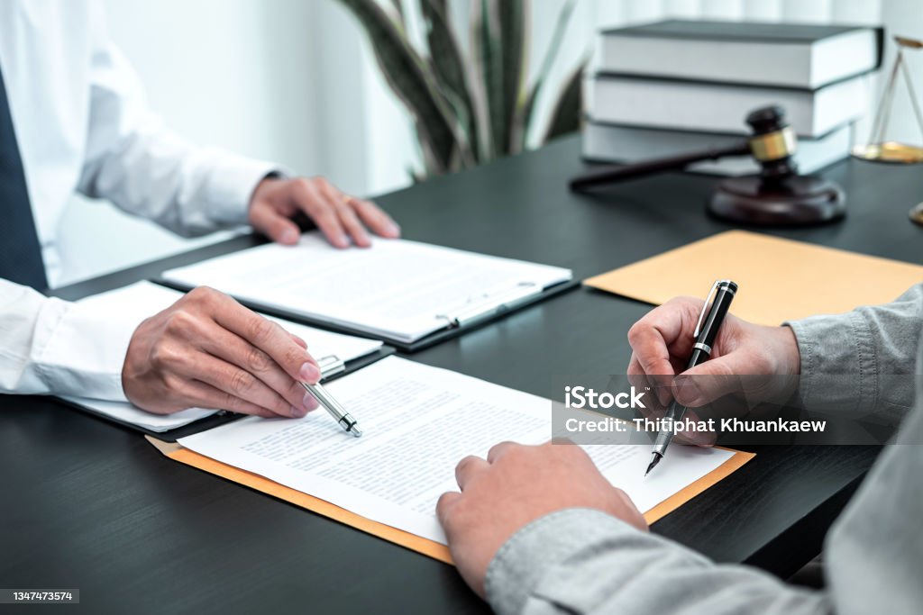 Male lawyer discussing negotiation legal case with client meeting with document contact in courtroom, law and justice concept Male lawyer discussing negotiation legal case with client meeting with document contact in courtroom, law and justice concept. Lawyer Stock Photo