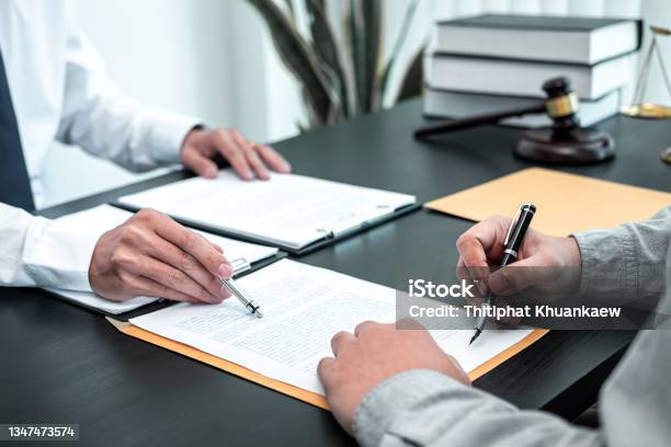 Male Lawyer Discussing Negotiation Legal Case With Client Meeting With Document Contact In Courtroom Law And Justice Concept Stock Photo - Download Image Now
