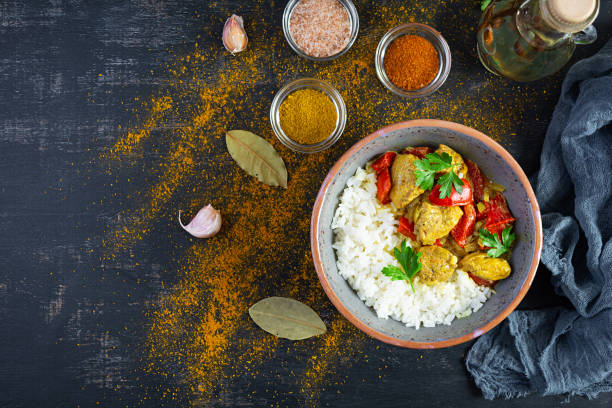 istock Spicy chicken curry with rice. Curry sauce with chicken and rice on dark background. Top view 1347474045