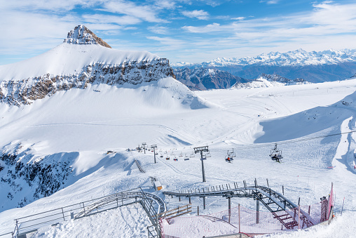 A landscape in Diablerets glacier at 3000 meters above sea level in Switzerland with chairlift and other rail transport on snowy mountain in a winter day