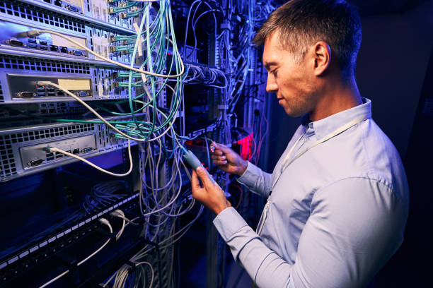 administrator systemu wykonujący testy diagnostyczne na serwerach komputerowych - network server data center installing zdjęcia i obrazy z banku zdjęć