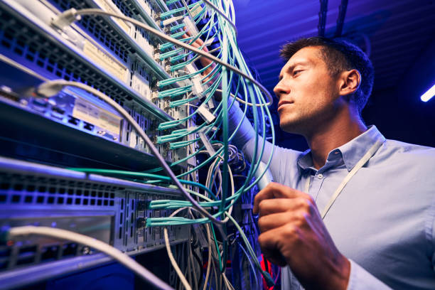 ingeniero que prueba las conexiones de cable en el servidor de red - fiber optic technology cable computer network fotografías e imágenes de stock