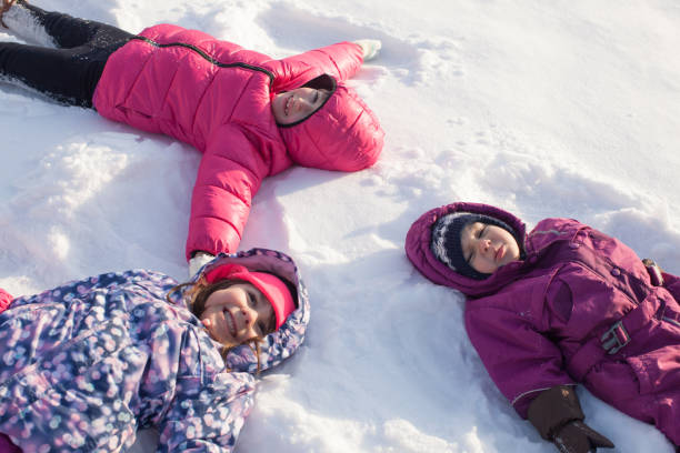 istock Rear View Of People Lying On Snow 1347476979