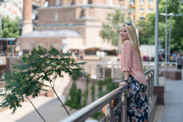 Beautiful young woman in the city waiting for her date