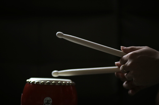 Human hand practicing drumming using dummy drum.