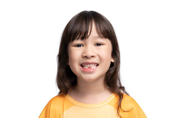 istock Cute girl opens her mouth to show her missing teeth. Tooth loss by age concept, replacement of permanent teeth. Tooth removal. 1347486659