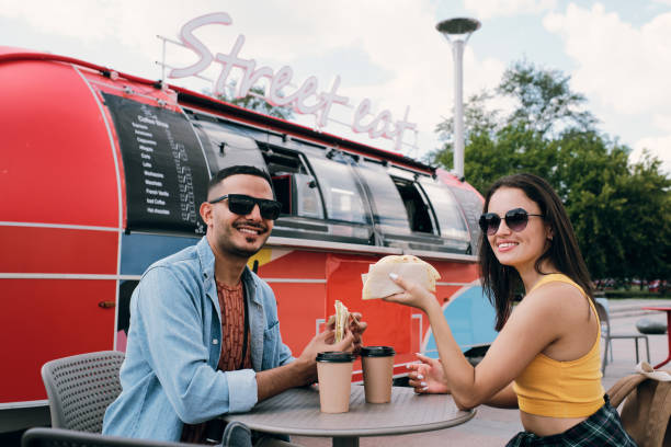 istock Happy young dates having fast food and drinks by table 1347486823