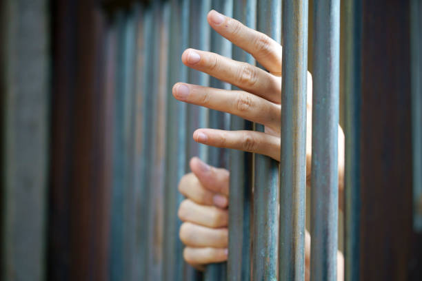 istock prisoner's hand in jail 1347488389