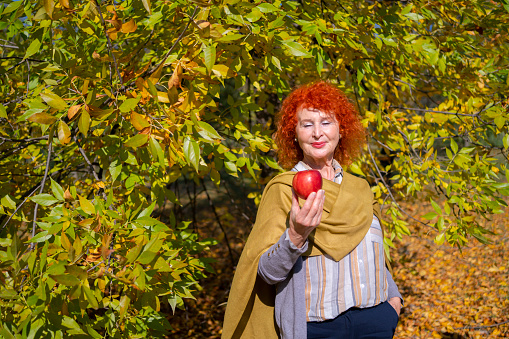 Mature woman is holding a red apple in her hand.Health and healthy eating concept.