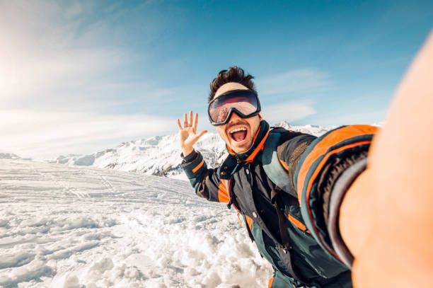 해변에서 셀카를 찍는 행복한 스키어 - 겨울 숲에서 활강 스키를 즐기며 즐거운 시간을 보내는 청년 - adventure 뉴스 사진 이미지