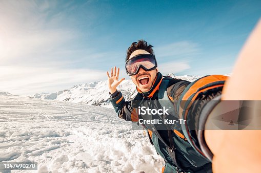 istock Happy skier taking a selfie on the mountains - Young man having fun skiing downhill in winter forest 1347490270