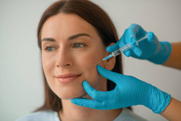 cosmetologa che inietta collagene al viso dei suoi clienti - attractive female human collagen syringe injecting foto e immagini stock