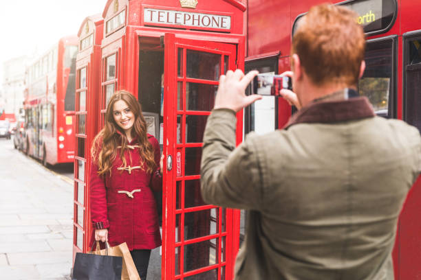 glückliche paare beim einkaufen und fotografieren in london - pay phone telephone people women stock-fotos und bilder