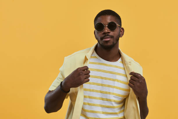man wearing sunglasses on yellow - men's fashion stockfoto's en -beelden