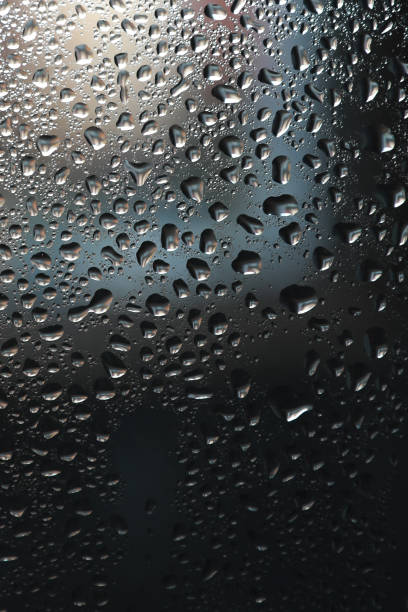 istock Close up of water drops on light tone background. Abstract black wet texture with bubbles on window glass surface or grunge 1347496578