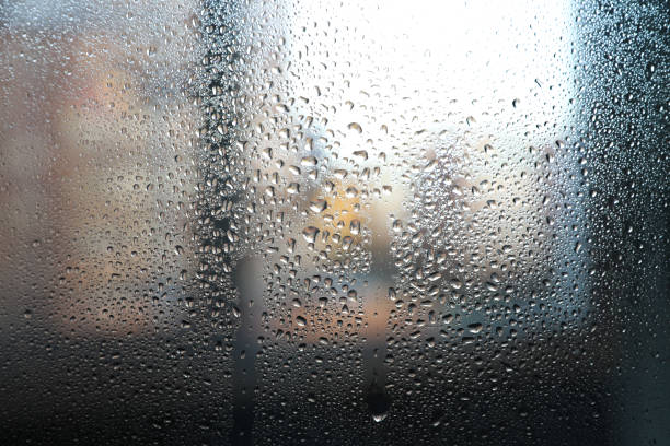 istock Close up of water drops on light tone background. Abstract black wet texture with bubbles on window glass surface or grunge 1347496600