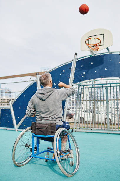 istock Man in wheelchair playing basketball 1347497040